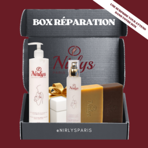 Box Réparation Nirlys Paris contenant un lait corporel éclat hydratant, une lotion nettoyante, deux savons (curcuma et exfoliant au baobab), et un cadeau surprise emballé d’un ruban doré. Le tout présenté dans une boîte noire élégante avec l’inscription “Une surprise vous attend dans votre box” en haut à droite.